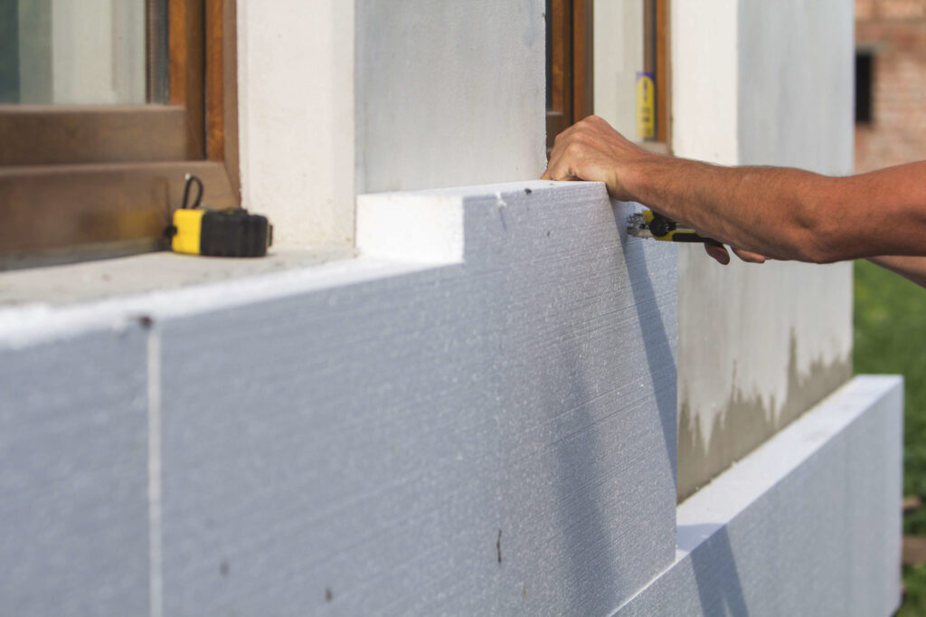 Découpe de bloc de polystyrène pour isoler par l'extérieur la façade d'une maison