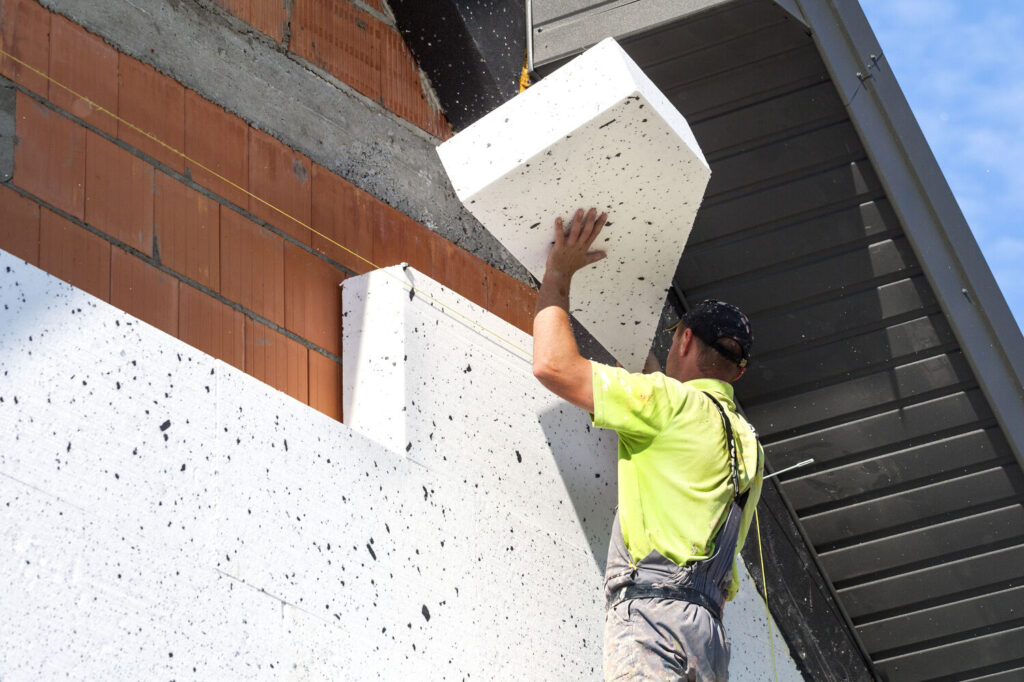 Pose de bloc de polystyrène isolant sur façade de maison